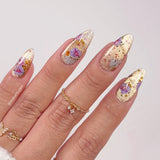 Nails with floral and gold cat eye gel polish designs on a light background