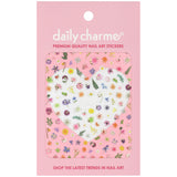 A package of Daily Charme nail art stickers featuring a variety of colorful pressed flowers and green leaves on a pink backing card.