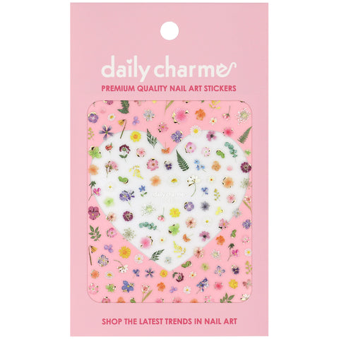 A package of Daily Charme nail art stickers featuring a variety of colorful pressed flowers and green leaves on a pink backing card.